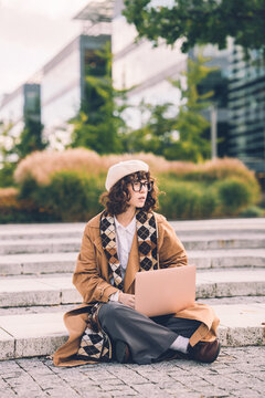 Stylish Student works on laptop outside university campus