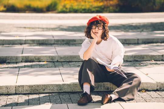 Student sitting on steps reading outdoors at university campus