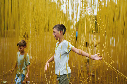 Children exploring immersive yellow art installation in a park