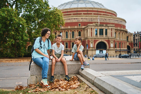 Mother and two boys relaxing outside Royal Albert Hall in London
