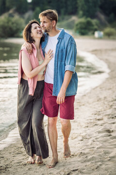 A loving couple enjoys a beach walk during summer vacation