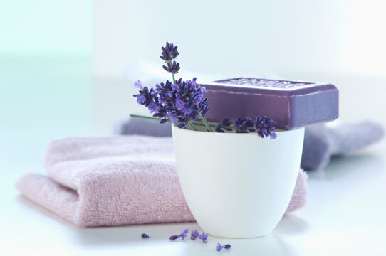 Lavender flower with lavender soap and towel on white background, close up