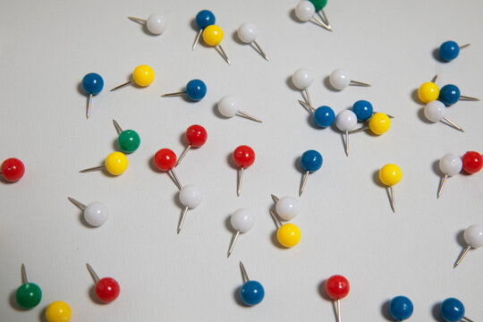 Multi colored scattered pin arrangement on a white background