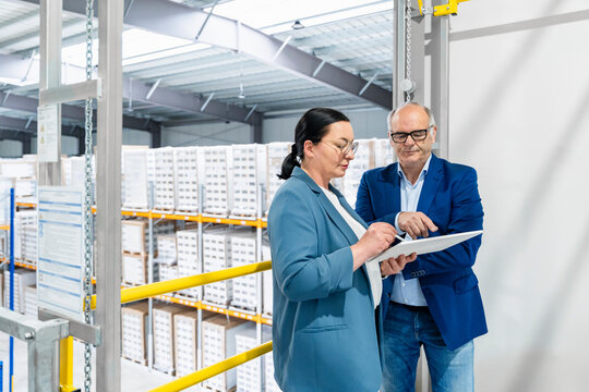 Manager and supervisor plan logistics with a tablet in warehouse