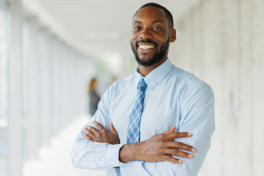 A confident businessman shows a warm smile in a bright office