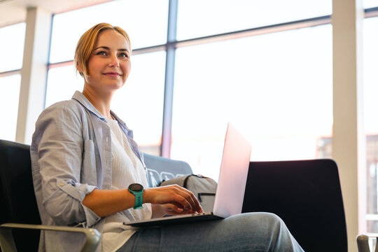 Businesswoman uses laptop computer at the airport waiting area