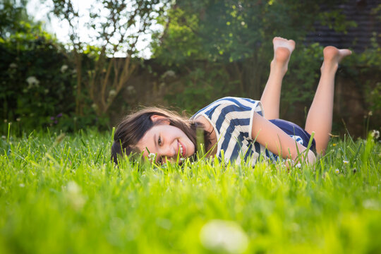 Portrait of smiling girl lying on a meadow in summer