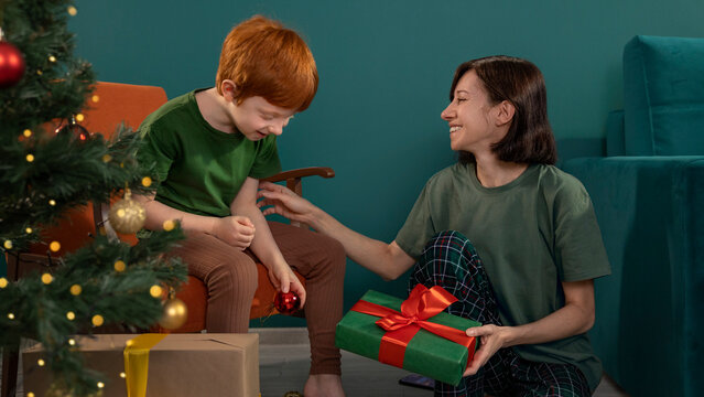 Mother gives a Christmas gift to her son at home