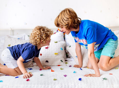 Two little brothers playing on the couch at home