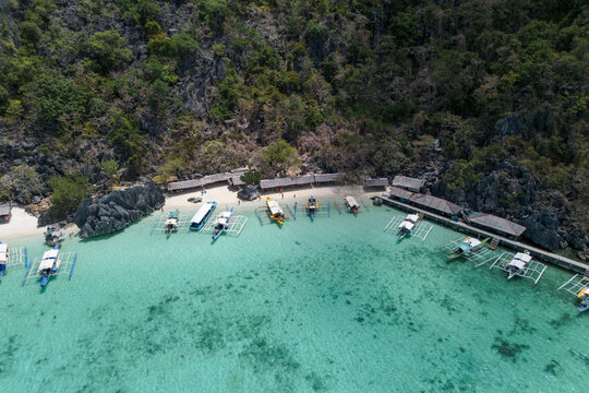 Traditional boats float on clean water in Coron Palawan paradise