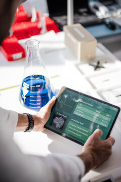Male scientist analyzes medical data on a tablet in laboratory