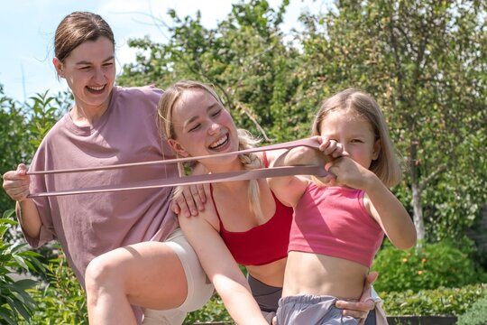 Active family pulls a resistance band during an outdoor workout