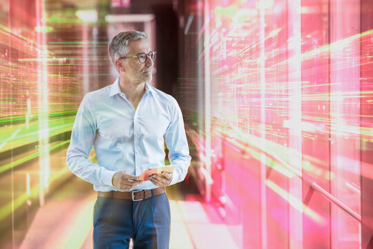 The male engineer holds a tablet in the futuristic office building