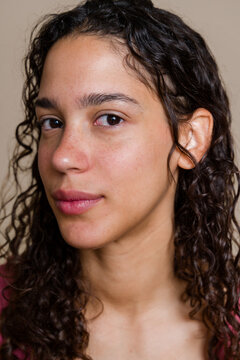 Hispanic woman with curly hair and freckles in a beauty shoot studio