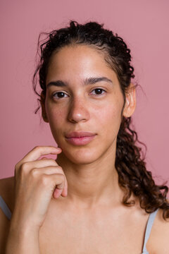 Portrait of young Hispanic woman with curly hair and freckles