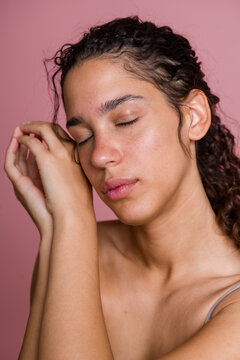 Young Hispanic woman with closed eyes resting face on hands