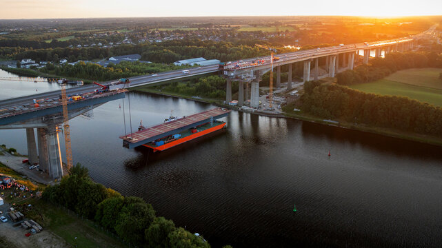 Aerial view of massive steel bridge segment on pontoon barge prepared for lifting at Rader High Bridge construction site over Kiel Canal.