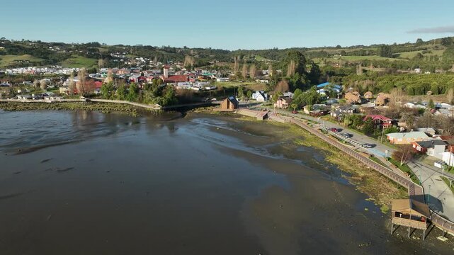 Following the tidal shoreline of Curaco de V&eacute;lez, the drone arrives at the town's plaza and stone church, a straight main street leading visitors into the heart of this Chilo&eacute; town.
