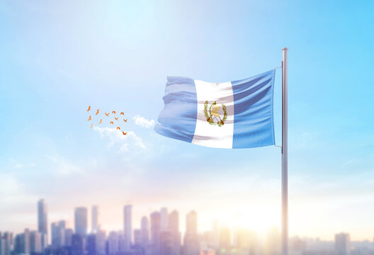 Guatemala national flag waving with skyline and buildings. Guatemala national flag for independence day.
