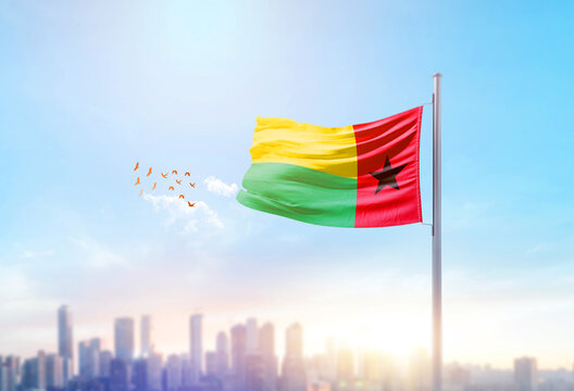 Guinea-Bissau national flag waving with skyline and buildings. Guinea-Bissau national flag for independence day.