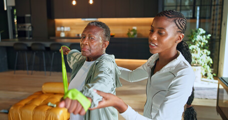 Personal trainer, resistance bands and fitness with black women in home for help, geriatric health...