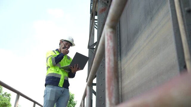 Engineer uses tablet beside water gate structure to document inspection findings and assess equipment condition at water management facility.