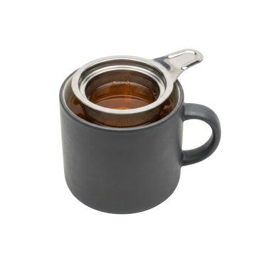 Dark grey mug with a metal tea infuser containing amber tea, isolated on a transparent background.
