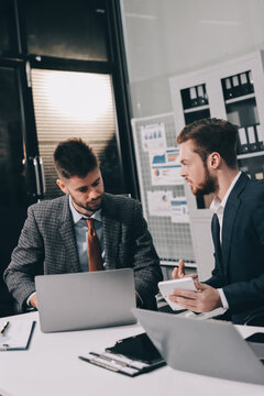 Business team collaborating on digital data analysis in modern office