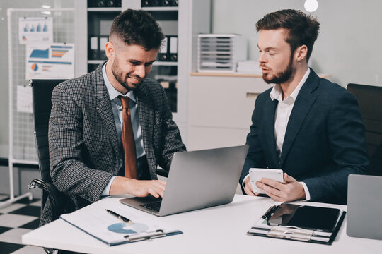 Business team collaborating on digital data analysis in modern office