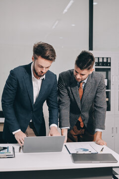Business team collaborating on digital data analysis in modern office