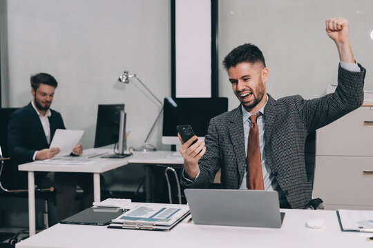 Two partners, team of professional business people working, discussing, writing notes at desk. Mature focused senior mentor leader man showing young woman manager project on laptop in modern office