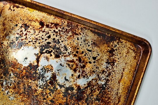 Dirty stained cookie sheet aluminum baking pan bakeware cleaning concept.