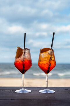 Two Aperol Spritz cocktails by the sea on a summer beach