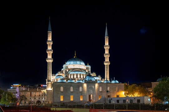 Istanbul,turkey,august 4, 2025. Yeni cami mosque showcasing its detailed ottoman architecture and towering minarets under night illumination in istanbul