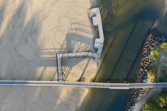 Downward aerial view of Back Creek Bridge crossing the sandy tidal creek and clear coastal water at South West Rocks, New South Wales, Australia.