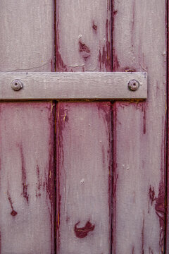 Aged Purple Wooden Door with Peeling Paint, Weathered Surface, Metal Latch Detail, Screws, Rustic Vintage Texture Background
