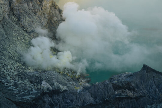 Sulfur steam rising from the active volcanic crater lake at Kawah Ijen in East Java Indonesia