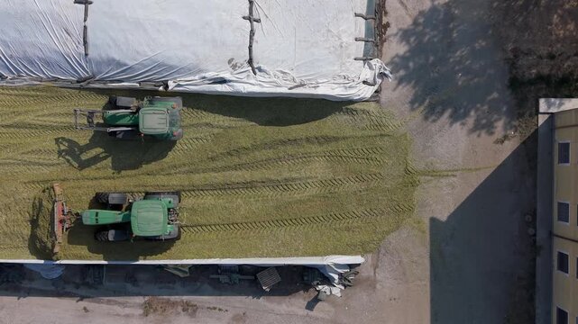 Aerial Farming Operation Preparing Grass for Livestock Feed in Silage Pit Italy