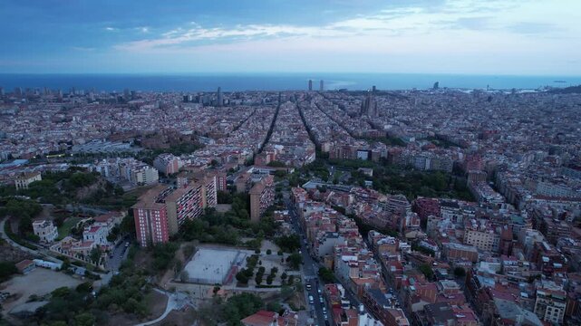 Aerial view of Barcelona skyline at dusk from Bunkers del Carmel with Sagrada Familia and Mediterranean Sea, Catalonia, Spain