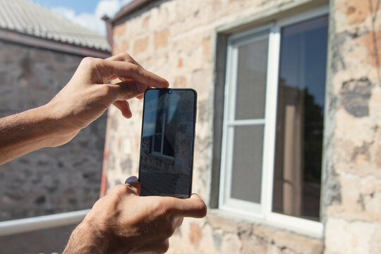Man taking window by mobile phone.