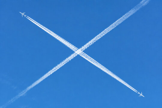 Aerial view of two jet planes crossing, creating white cross contrail.