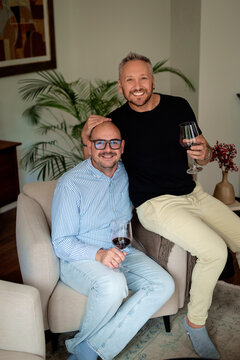 Gay couple relaxing on an armchair at home