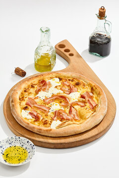 Carbonara pizza with curled bacon, cream cheese pools and golden crust on a white background for restaurant menu