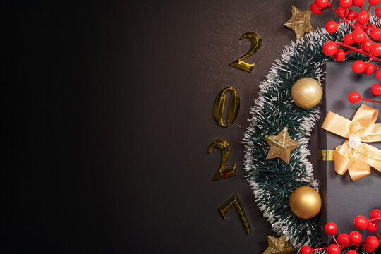 Happy New Year 2027 concept with gift box and gold decorations on dark background