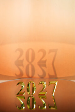 Golden 2027 numbers with reflection for New Year celebration background