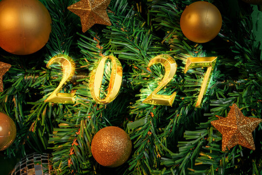 Golden 2027 numbers on Christmas tree branches for holiday background