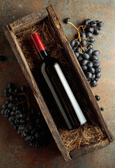 Obraz premium Bottle of red wine in an antique wooden box.