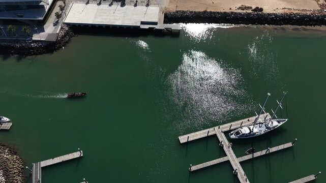 Top view from drone of sailboats and various speed boats in dock. Aerial view of luxure yachts and motorboats moored in a port with clear blue water in summer. Vilamoura, Algarve, Portugal