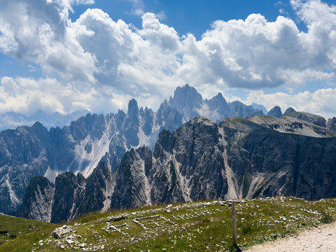 panorama of Tre Cime in the Dolomites, highlighting jagged cliffs and green meadows 