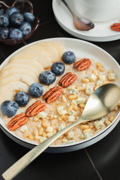Oatmeal. Bowl of oatmeal porridge with blackberry, bananas and chia seeds on gray concrete old table background. Top view in flat lay style. Natural ingredients. Hot healthy breakfast and diet food